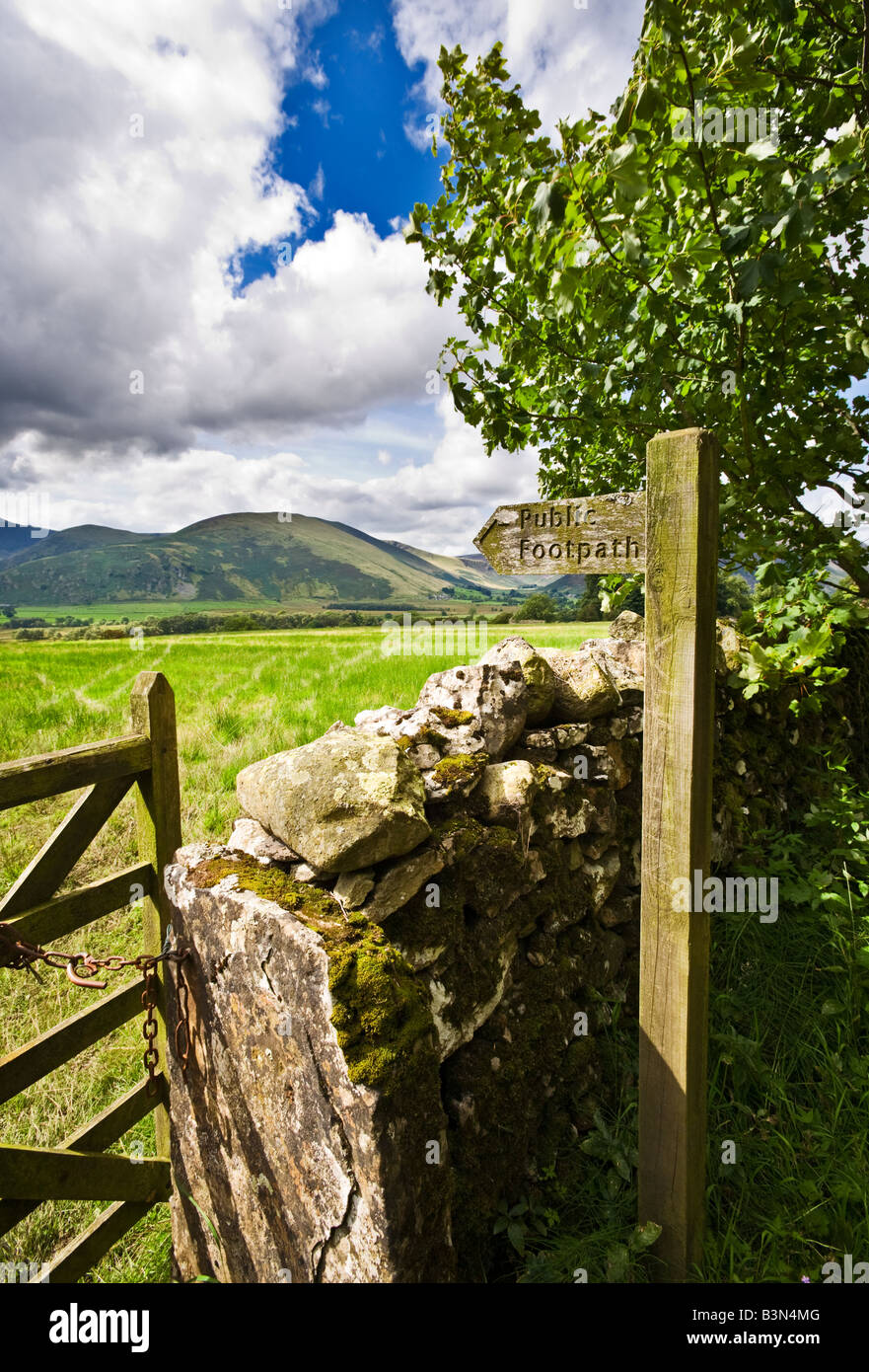 Typisch Englisch Lake District Landschaft Szene mit hölzernen Richtung Wegweiser zu trocknen, Steinmauer und Tor Cumbria England UK Stockfoto