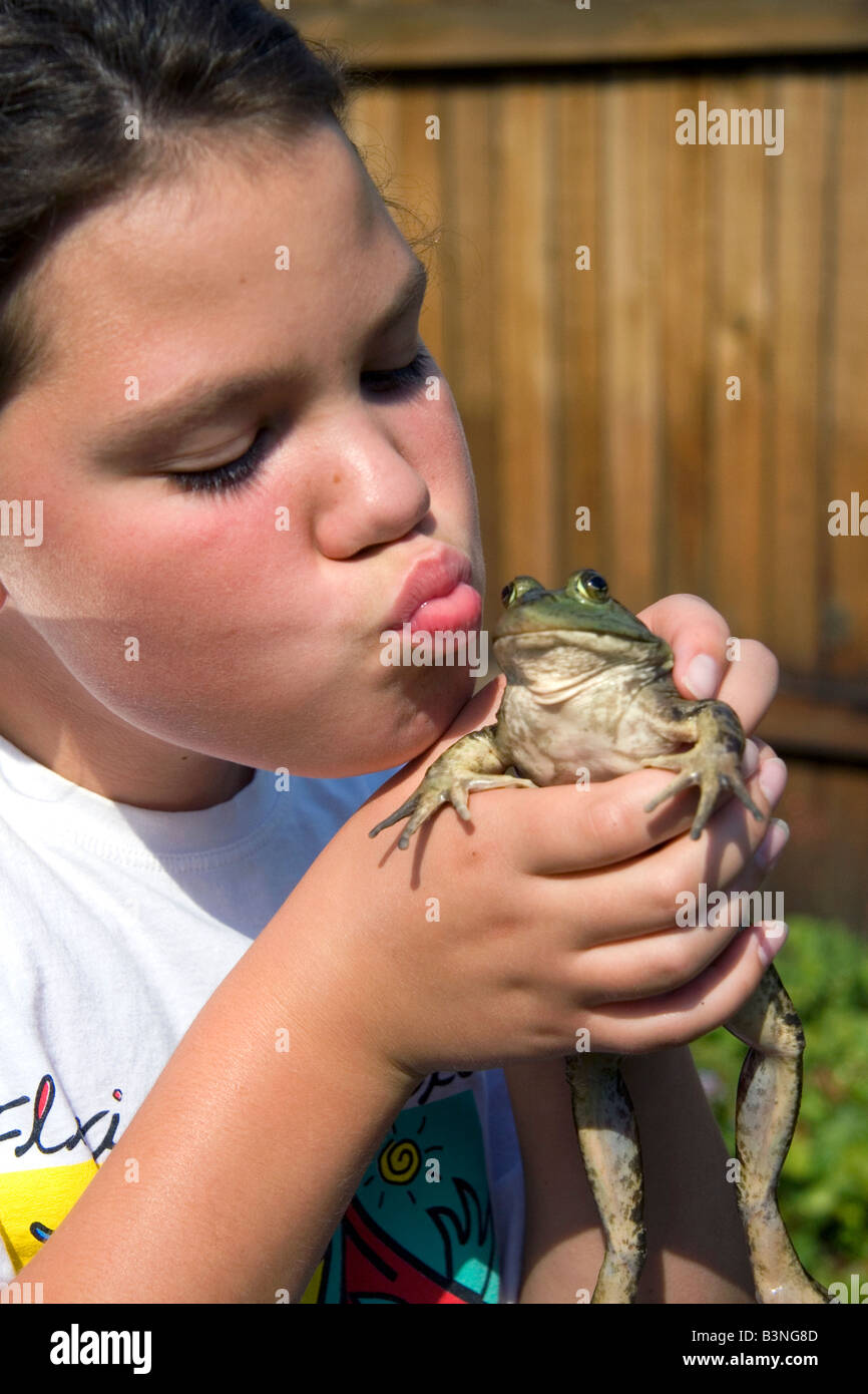 11 Jahre altes Mädchen küssen ein Ochsenfrosch in Boise, Idaho Stockfoto