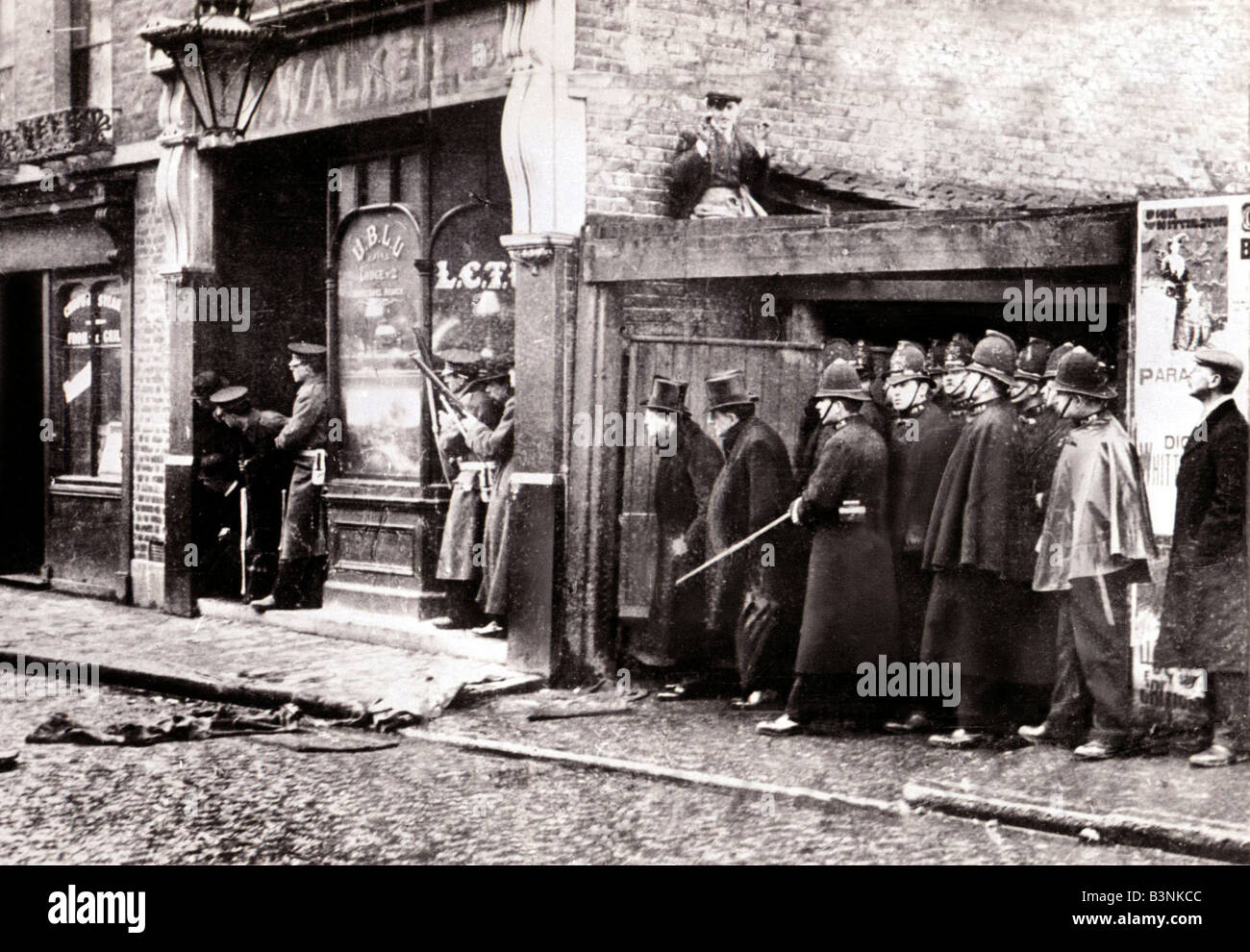 Sidney Street In Ende 1910 eine Ostende Mob gefangen Tunnelbau in ein Juweliergeschäft verbarrikadiert sich bei 100 Sidney Street Widerstand gegen die umliegenden Polizei mit Mausers während die Belagerung, die das Haus schließlich ersticken zwei Einbrecher, die Churchill fotografiert wurde, bei der Szene brannte, verleumdet werden, für die Aufdeckung selbst zur Gefahr für die Armen Einbrecher verbrennen zu lassen und stören die Polizei die Fakten bei der Angelegenheit in Kenntnis gesetzt, WSC an das Home Office ging die nichts wusste In der Regel er verließ den Ort des Geschehens aber nicht eingreifen, wenn das Haus fing Feuer der Polizei lassen Stockfoto