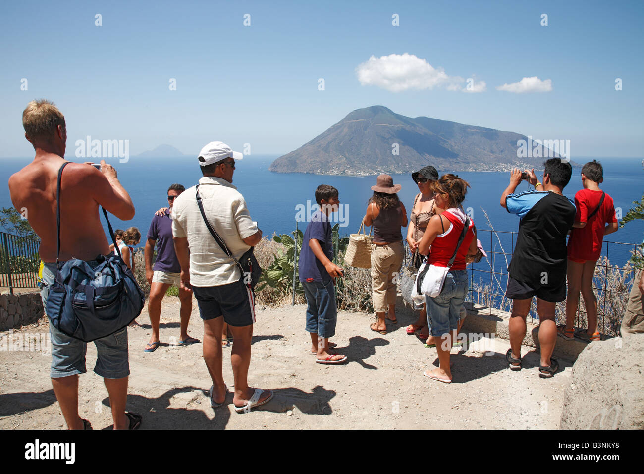 Italien, Sizilien, Provinz von Messina, Äolischen Inseln, Liparischen Inseln, Tyrrhenischen Meer, Mittelmeer, Lipari, Touristen auf die Insel Lipari-Blick über das Meer auf der benachbarten Insel Salina, nehmen Sie ein Bild, Vulkaninsel, zwei Vulkane Vulkan Fo Stockfoto