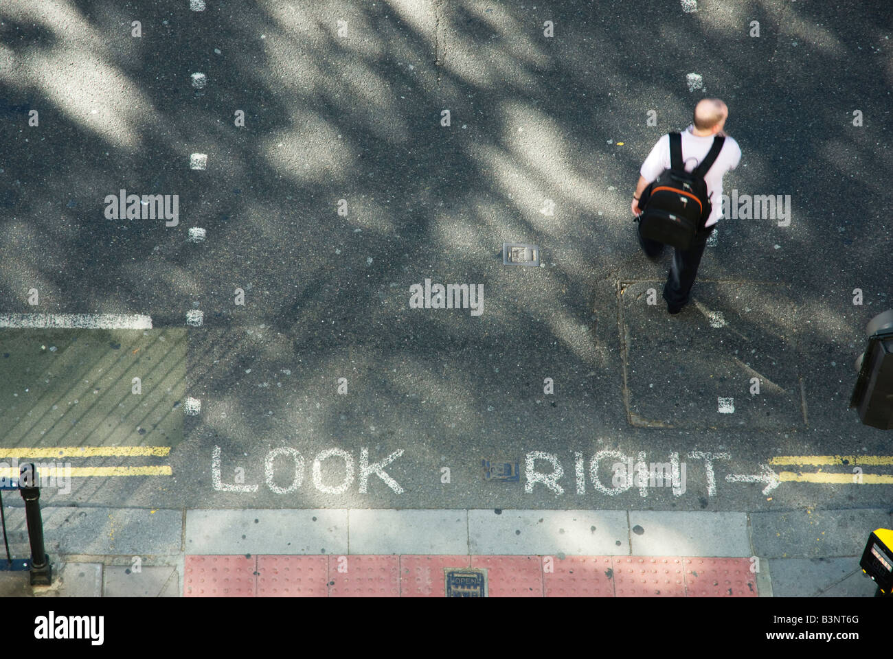 Ich schaue auf einen Mann mit Rucksack, der eine Londoner Straße überquert, wo es heißt, guck right Stockfoto
