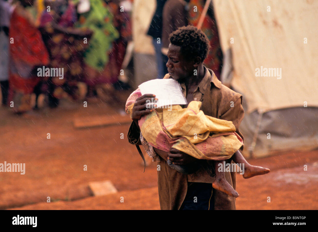 BURUNDIS ETHNISCHE KONFLIKTE ", BURUNDISCHEN FLÜCHTLINGEN IN RUANDA IM CAMP MOKINDO ENTHÄLT MEHR ALS 50.000. EIN VATER TRÄGT SEIN KIND Stockfoto