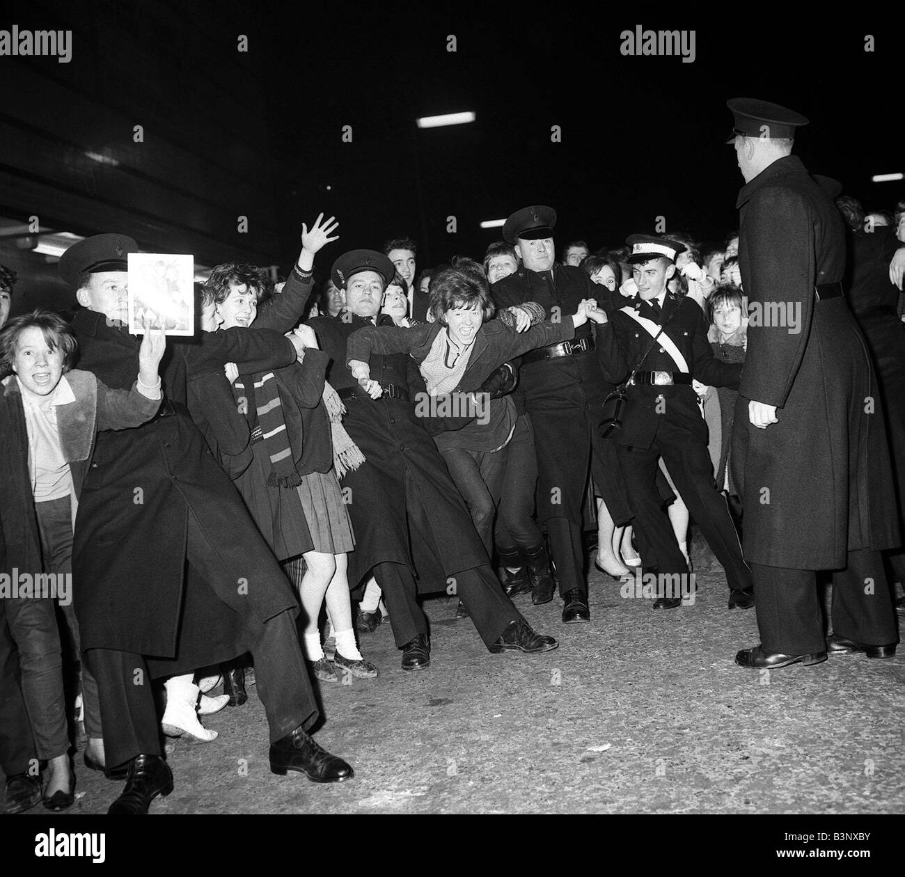 Pop Gruppe zurückhalten der Beatles November 1963 Polizei Fans und Massen, die darauf warten, einen Blick auf ihre Idole in East Ham erhaschen Stockfoto