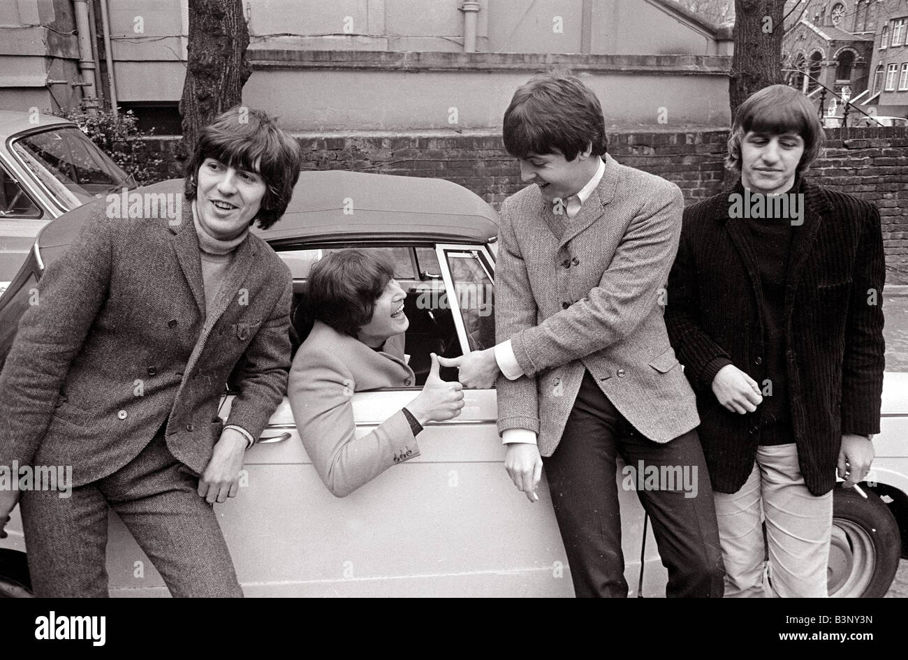 Die Beatles John Lennon s Auto, nachdem er seine L bestanden testen 15. Februar 1965 L R George Harrison John Lennon im Auto Paul McCar Stockfoto