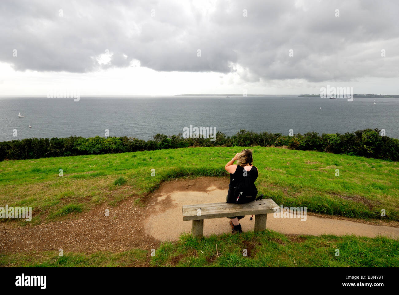 Eingang zum Hafen von Falmouth mit einzelnen Figur im Vordergrund Blick auf das Meer Stockfoto