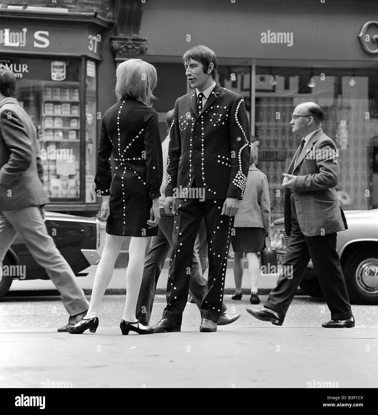Mode Mod Carnaby Street fashion Oktober 1966 Mod in der Carnaby Street London, ein Mann und eine Frau auf der Straße sprechen Stockfoto