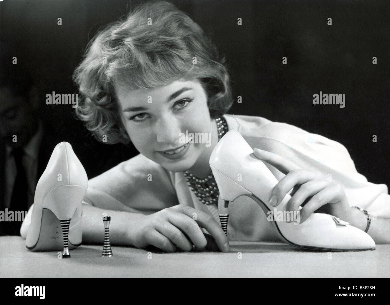 Eine Modell mit ein paar neuen Schuhen mit hohen Absätzen die Stahl Fersen, anschrauben und ab 1959 Schuhmode Schuhe Erfindung Erfindungen Frauen Frau 1950er Jahre Spiegel Stockfoto