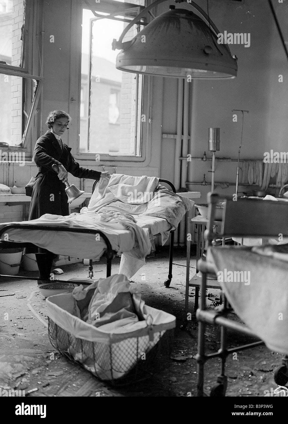 Eine Krankenschwester im OP-Saal nach einem Überfall 1941 während dem 2. Weltkrieg 1941 aufräumen Stockfoto