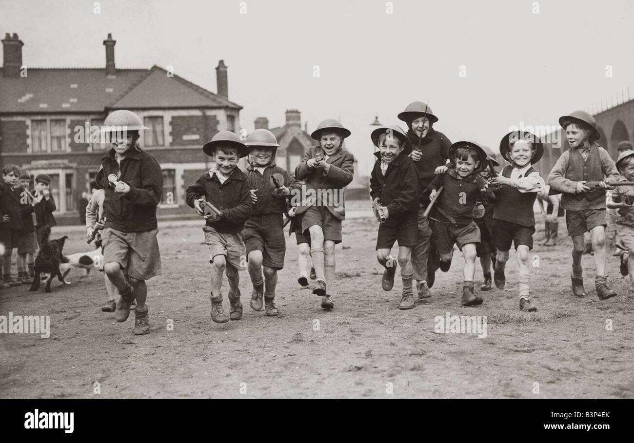 Cardiff Kinder 8 Kommando neue Spielzeug Zinn Helmen und Durchführung Spielzeug Gewehre kostenlos weiterleiten repräsentieren unsere zweite front Kinder laufen auf der Straße spielen über die Heimatfront Stockfoto