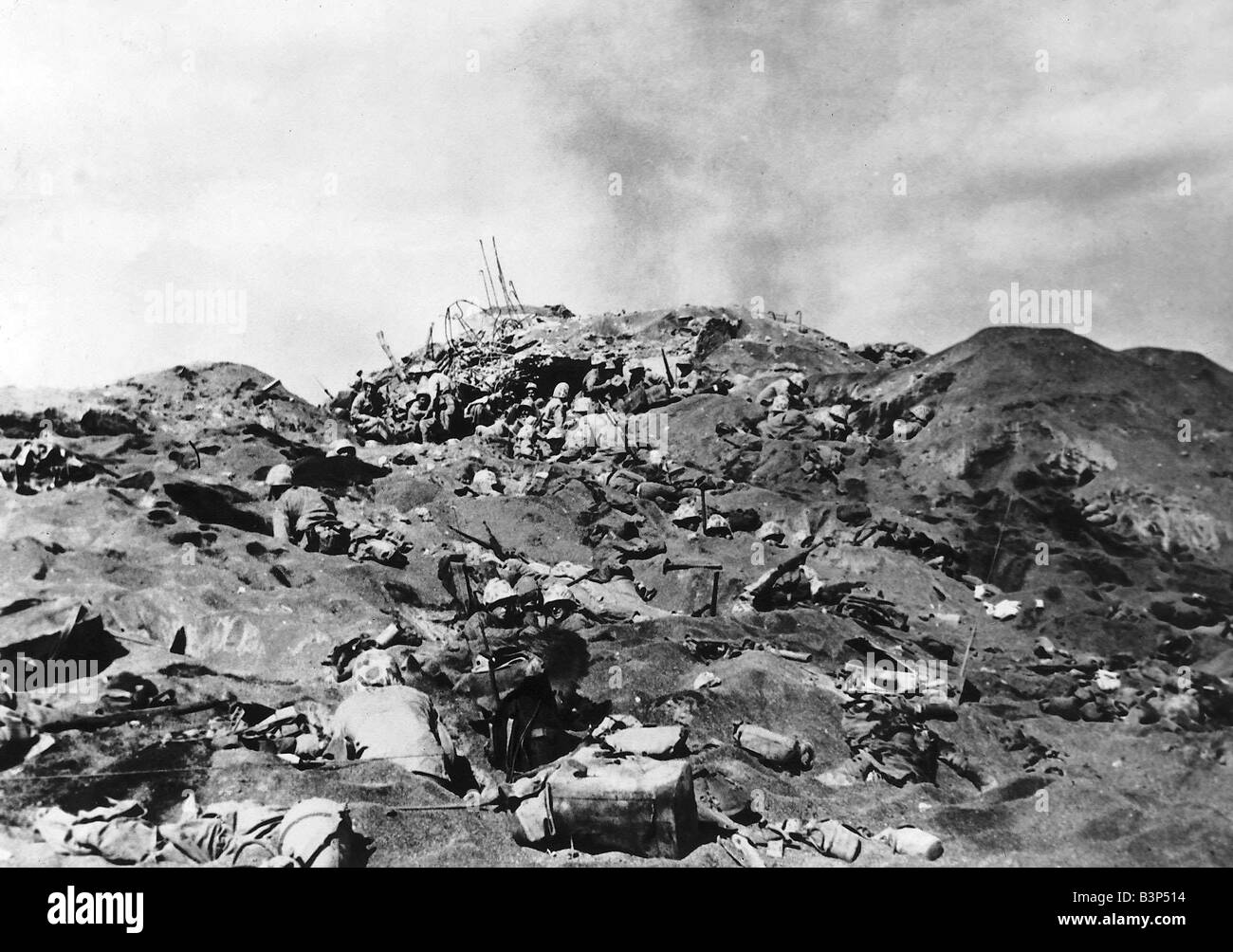 WW2 Marines lebendig und tot decken die vulkanische Sand dieses Bunkers auf IWO JIMA, nachdem japanische Pillbox im Hintergrund Elemente gerissen durch Granatsplitter verstreut über den Sand ausgeschlagen war Stockfoto