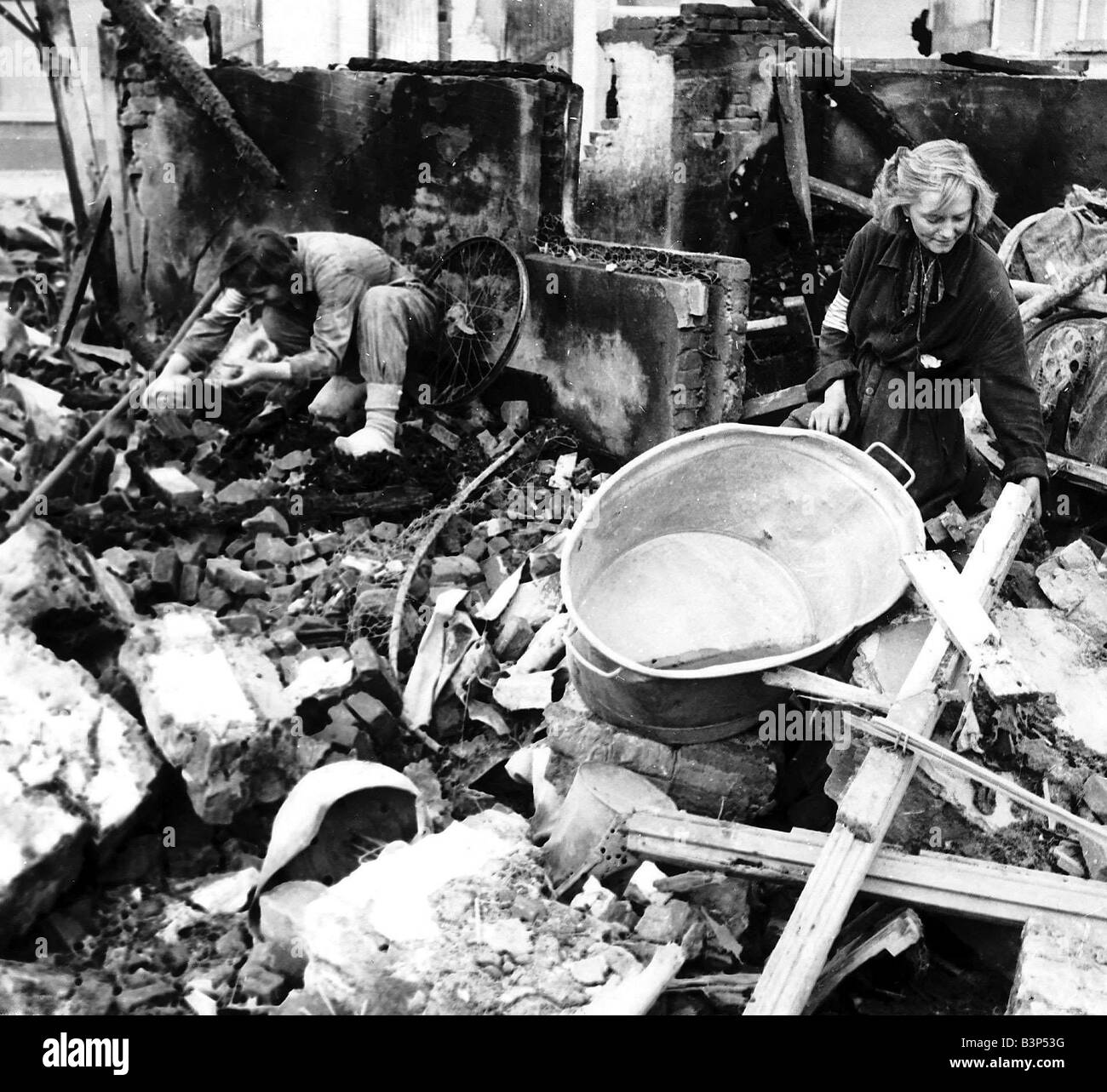 Mädchen-Retter suchen unter den Ruinen von Eindhoven nach ein weiterer Luftangriff der Luftwaffe auf Holland Stockfoto