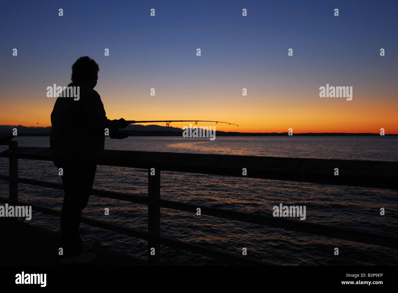 Eine Frau, die Fischerei auf Lachs aus dem Edmonds Fishing Pier. Stockfoto