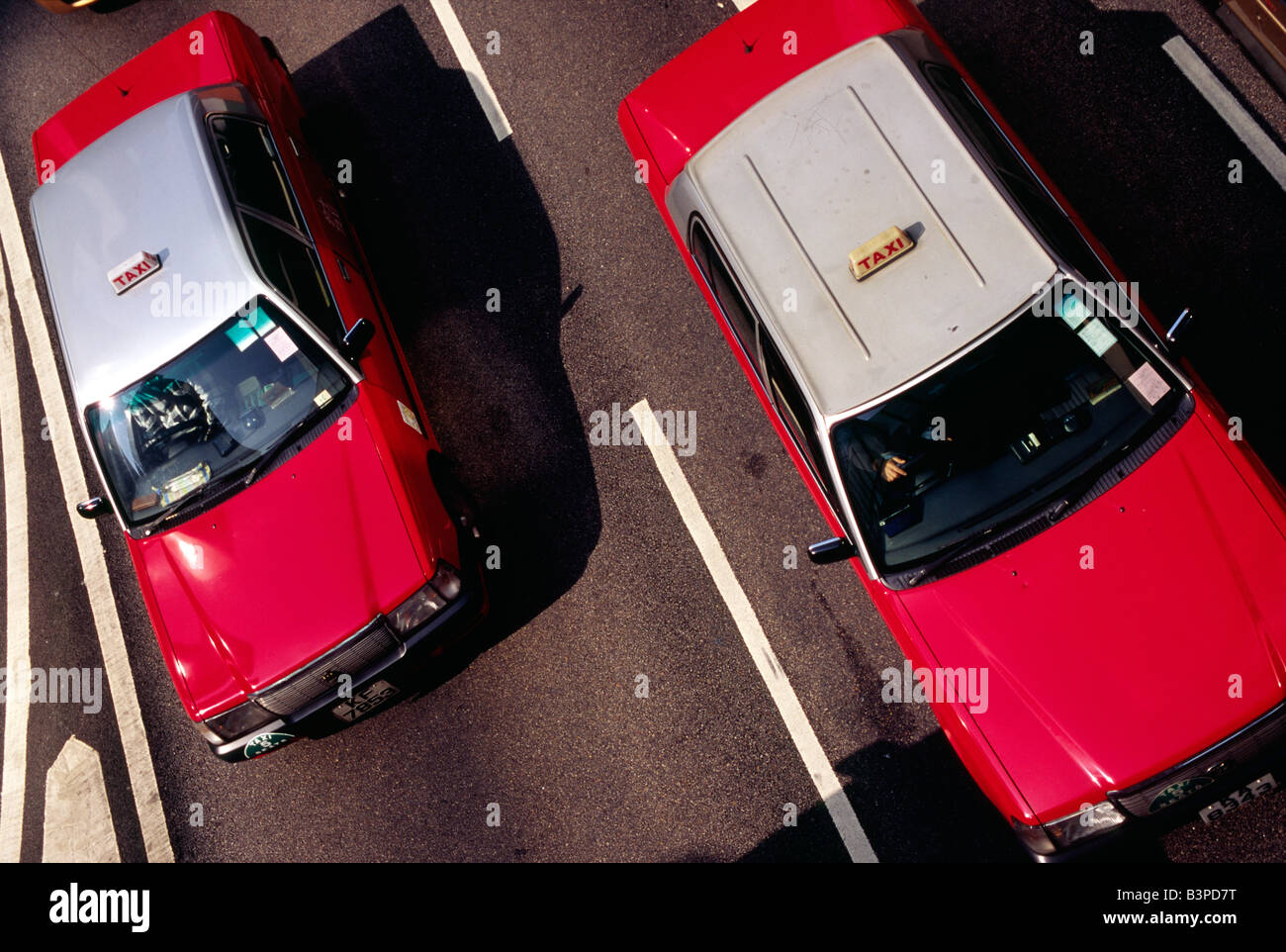 China, Hongkong, Central. Zwei von Hong Kongs unverwechselbaren roten und silbernen Taxis auf den Straßen des Finanzviertels Stockfoto