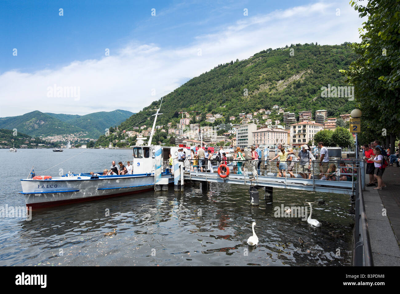 Touristen, die einsteigen in einer Fähre am Seeufer am Comer See, Comer See, Lombardei, Italien Stockfoto