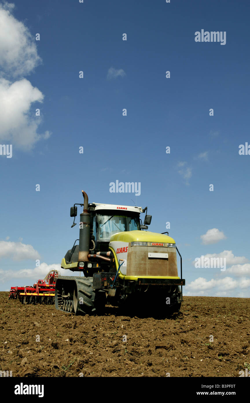Claas Traktor mit Gummilaufketten in Bebautes Feld im Sommer Motten nach der Ernte die Ernte beendet hatte, der Boden, der ist Vorbereitung Stockfoto