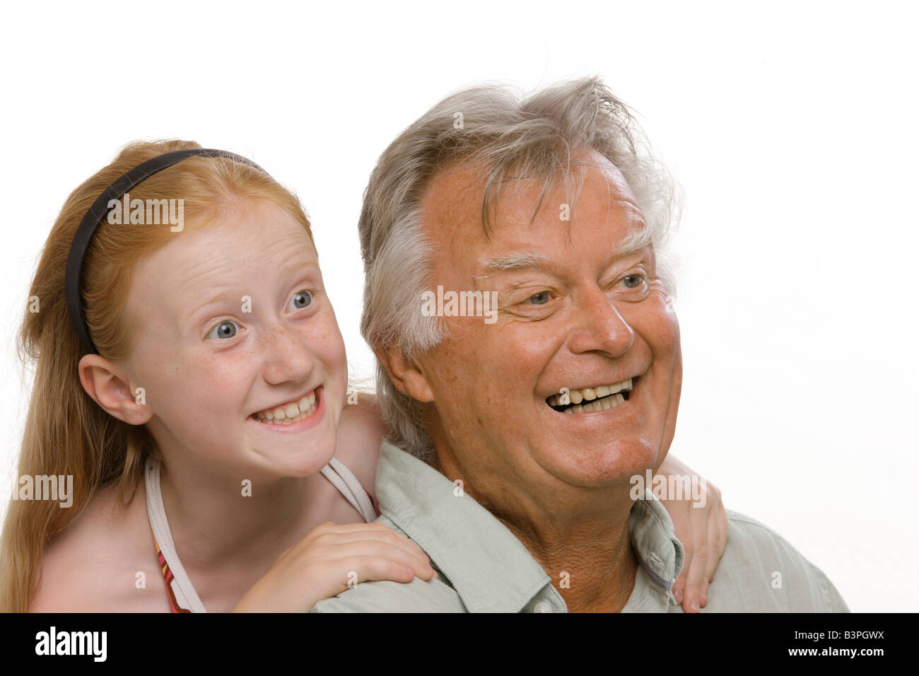 8-j hrige rothaarige Mädchen umarmt ihr Großvater und lachen Stockfoto