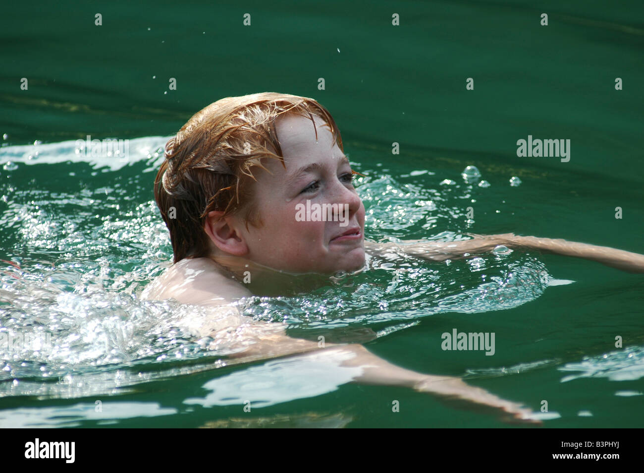 Zehn Jahre alten Jungen schwimmen in einem kalten frischen und sehr sauberen Bergsee in Österreich Stockfoto