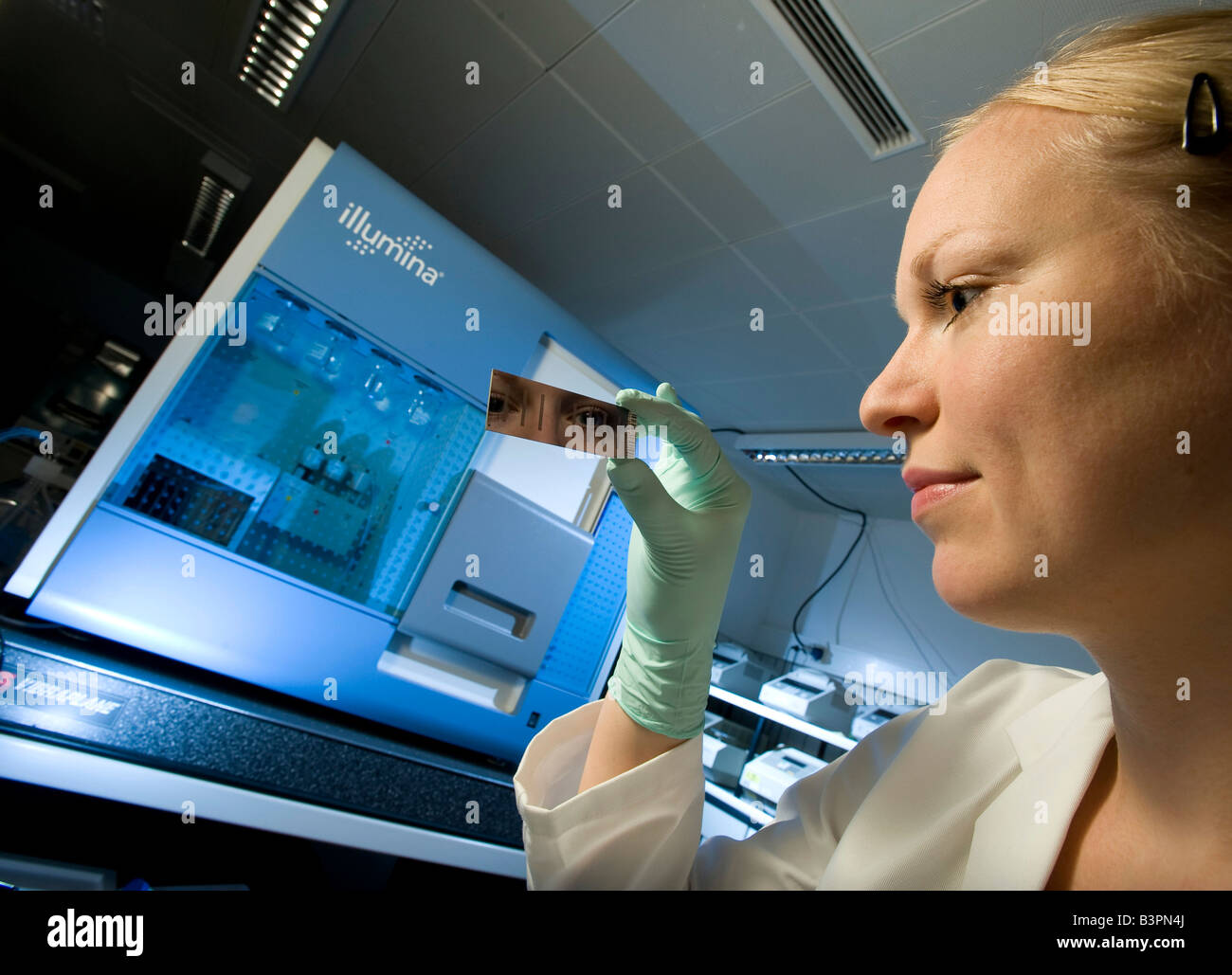 Weibliche Laborantin mit gen-Chip und Lesung Vorrichtung zur Sequenzierung und gen Expressions-profiling, Max-Planck-Institut Stockfoto