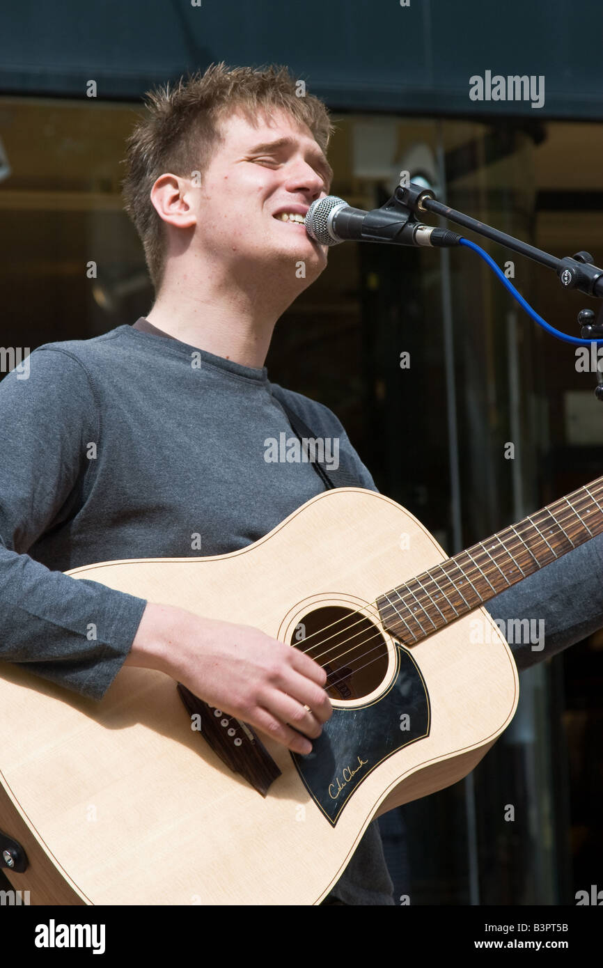 Straßenmusiker mit akustischer Gitarre singt auf der Straße Stockfoto