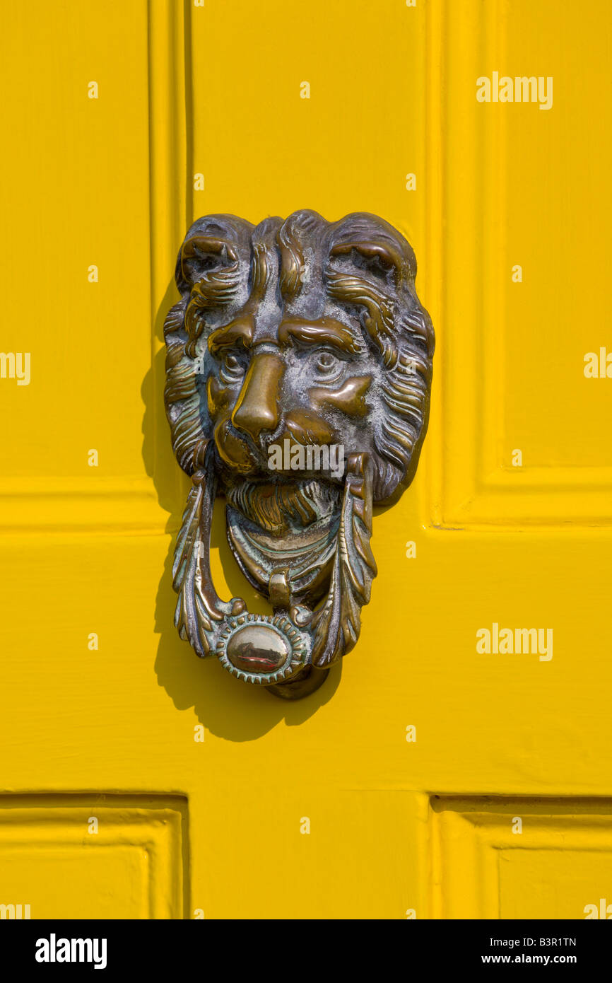 Messing-Klopfer auf gelb lackierte Tür, Long Melford, Suffolk, England Stockfoto