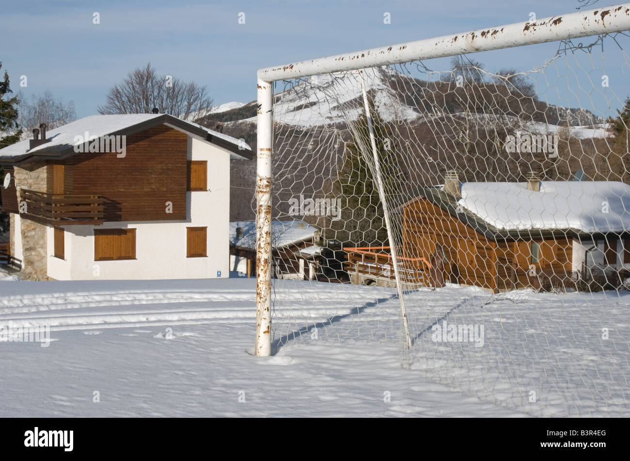 Fußball Netto neben einem verschneiten Bergdorf Italienische Alpen Stockfoto