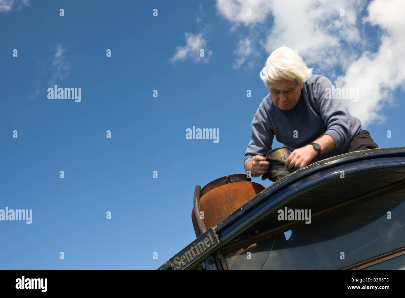 Man reinigt Brasswork auf einem alten Dampftraktor bei einer Dampf-Kundgebung. Stockfoto