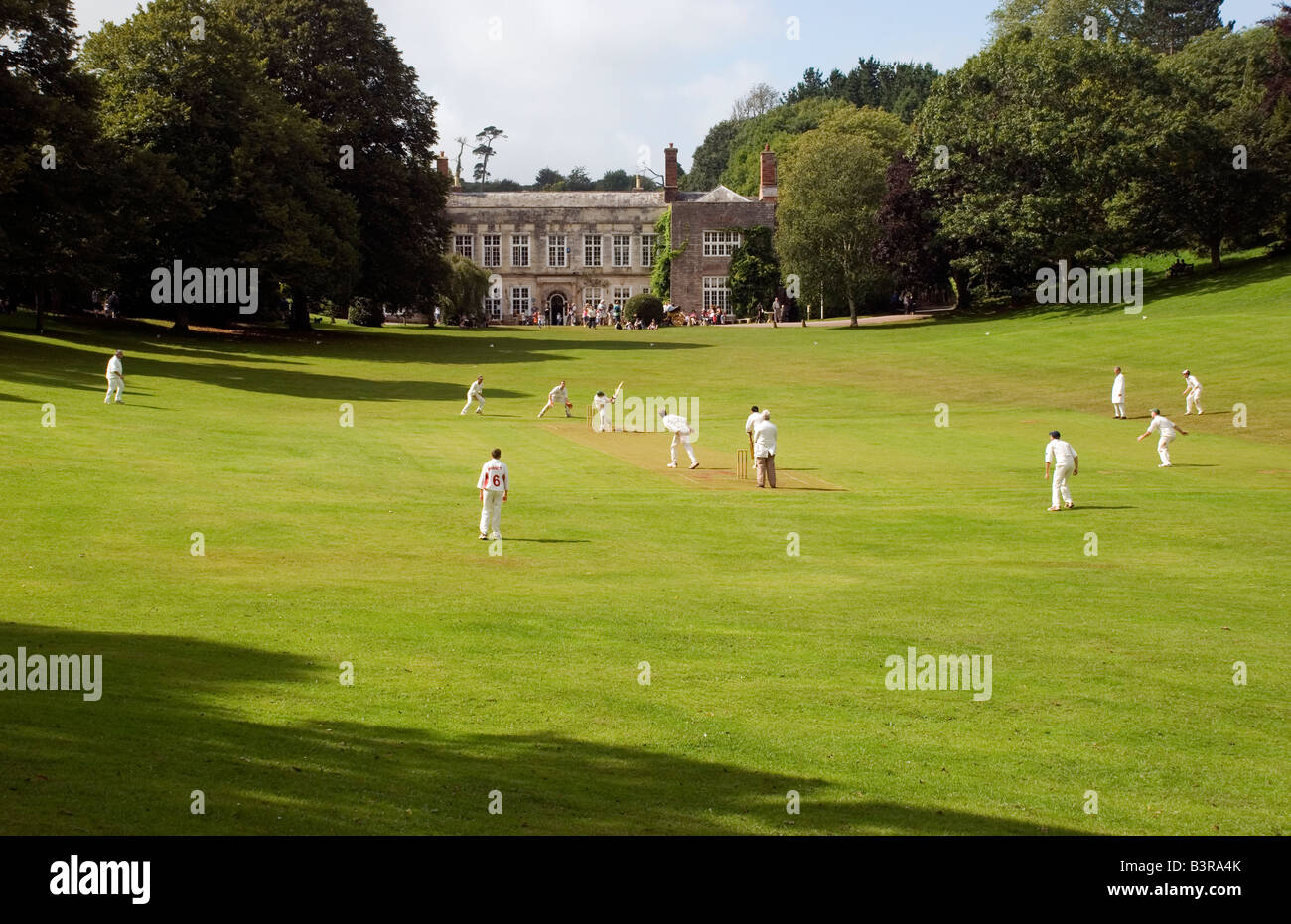 English Village Cricket, 17. Jahrhundert stammende Herrenhaus im Dorf Cockington, Torquay, Devon, Streifen, Pitch, cockington Hof, ideal, ideal, idealisierten, gewann Stockfoto