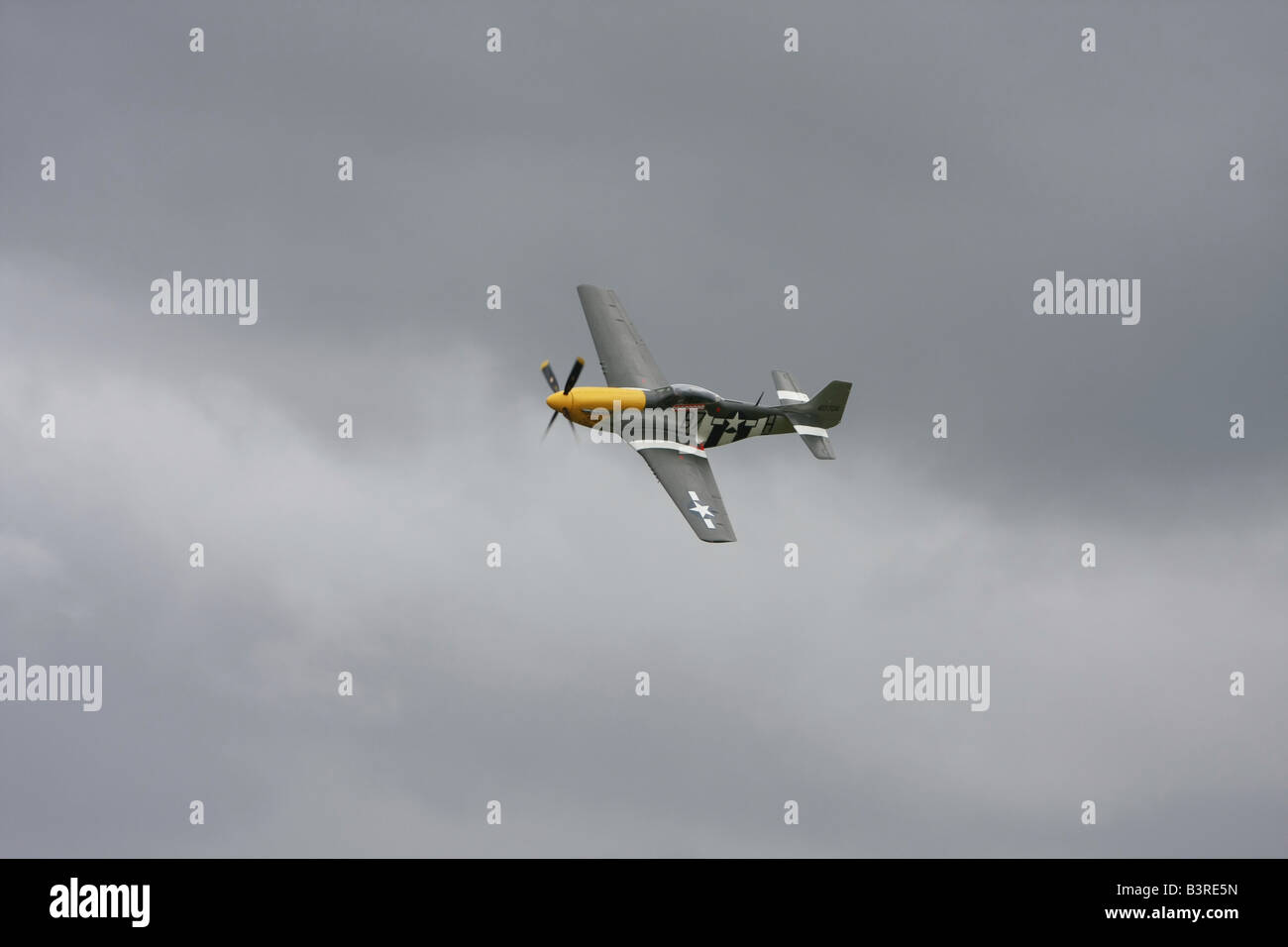 Ein P51D Mustang in einem schnell niedrigen Niveau passieren im Duxford mit einem stürmischen Himmel im Hintergrund. Stockfoto