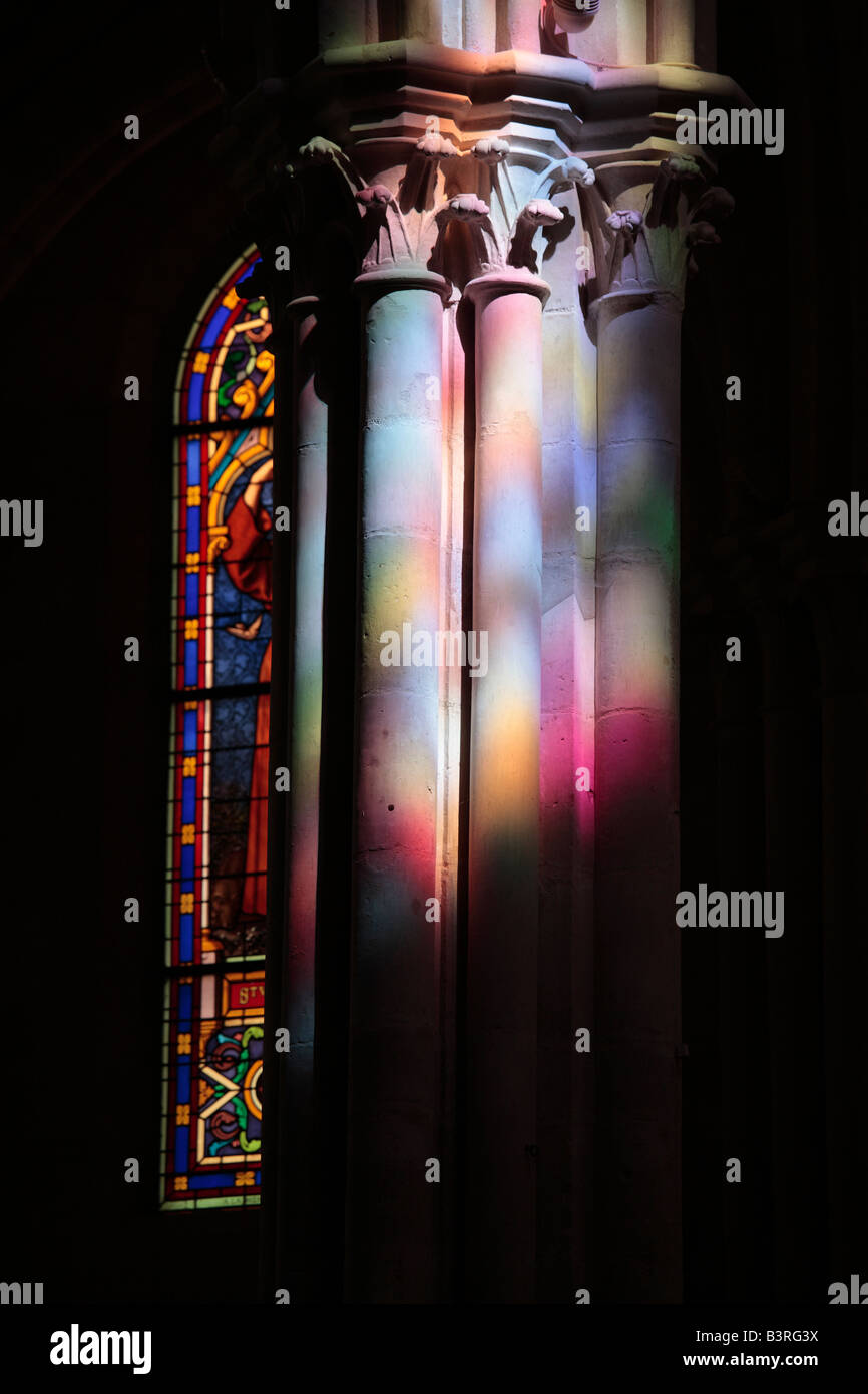 Glasfenster werfen farbiges Licht auf Spalten in der Kirche Saint-Martin in Clamecy, Nièvre, Frankreich. Stockfoto