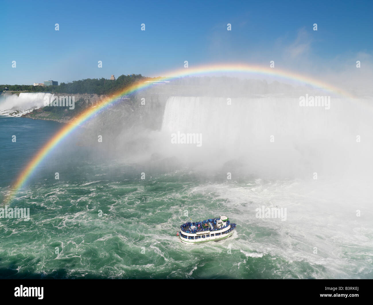 Kanada, Ontario, Niagarafälle, Mädchen der Nebel Tour Boot nähert sich die kanadischen Wasserfälle mit einem Regenbogen mit den American Falls Stockfoto