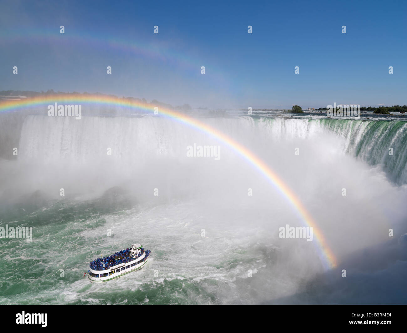 Kanada, Ontario, Niagarafälle, Mädchen der Nebel Tour Boot nähert sich die kanadischen Wasserfälle mit einem doppelten Regenbogen Stockfoto