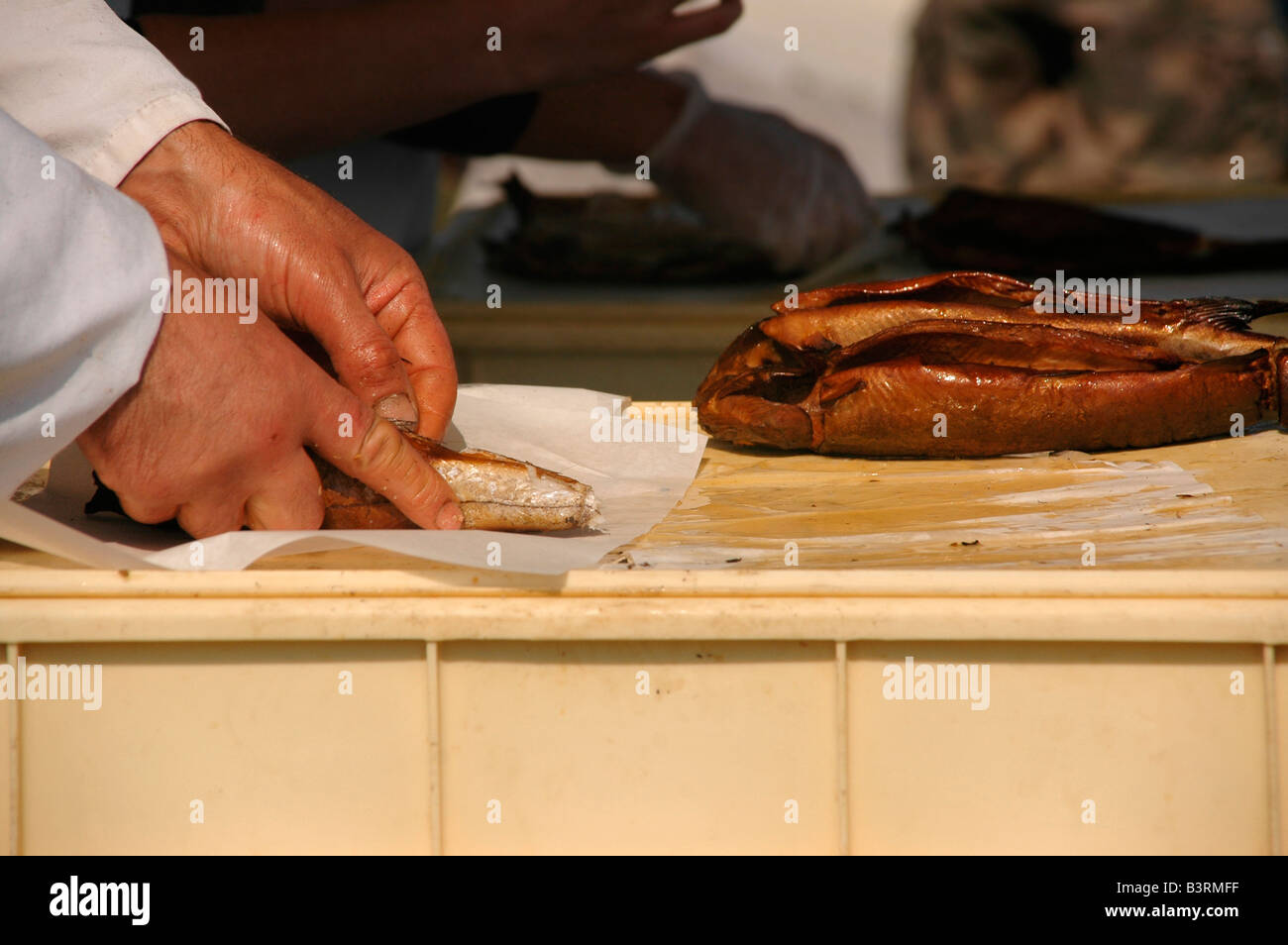 Ein Mann hüllt Arbroath Smokies für einen Kunden. Stockfoto