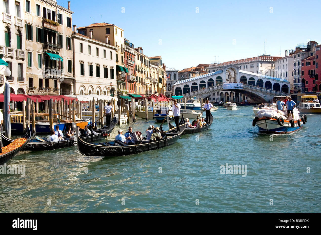 Gondeln und Schiffe in der Nähe der Rialto-Brücke am belebten Canal Grande in Venedig Stockfoto