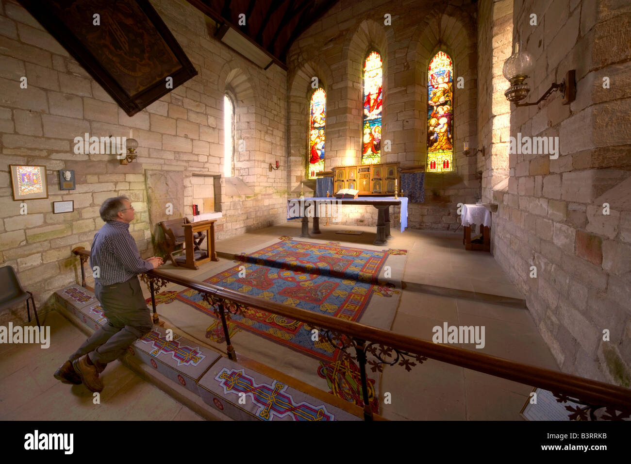 Mann, der betet in Kapelle, Holy Island, Bewick, England Stockfoto