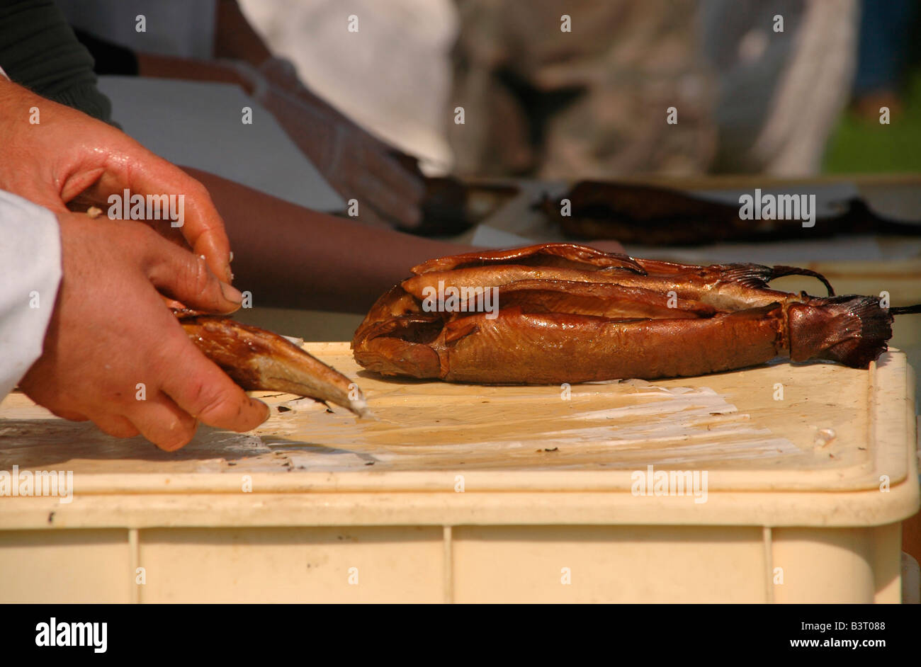 Ein Mann hüllt Arbroath Smokies für einen Kunden. Stockfoto