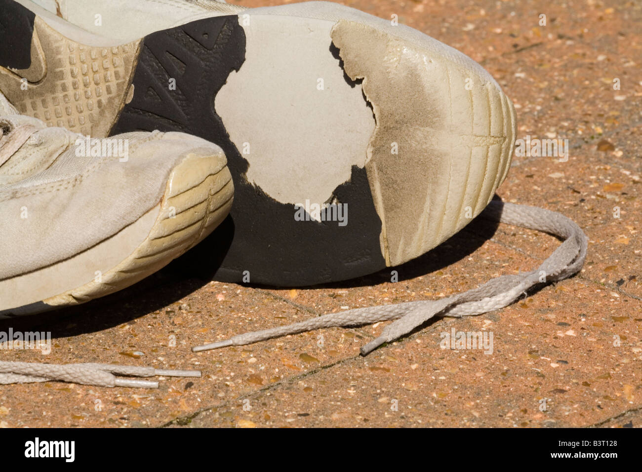 Ein paar der alten abgenutzt Trainingsschuhe auf einer Terrasse Stockfoto