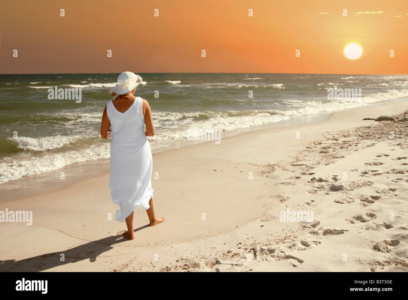 Eine Frau, die den Sonnenuntergang an der Golfküste von Alabama. Stockfoto