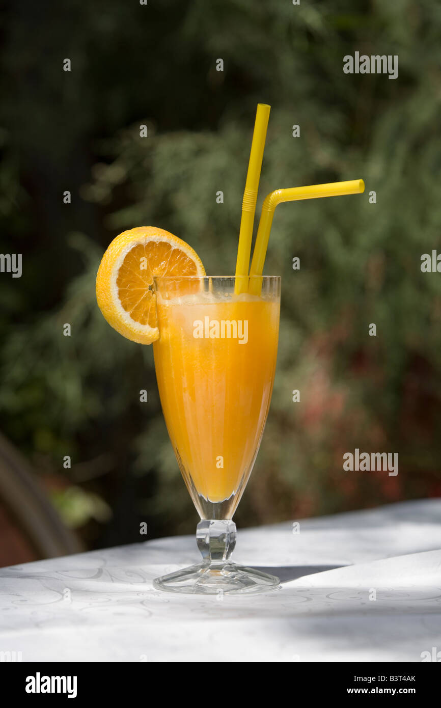 Großes Glas Orangensaft auf Tisch mit weißem Leinen vor Bäumen im Garten  Stockfotografie - Alamy