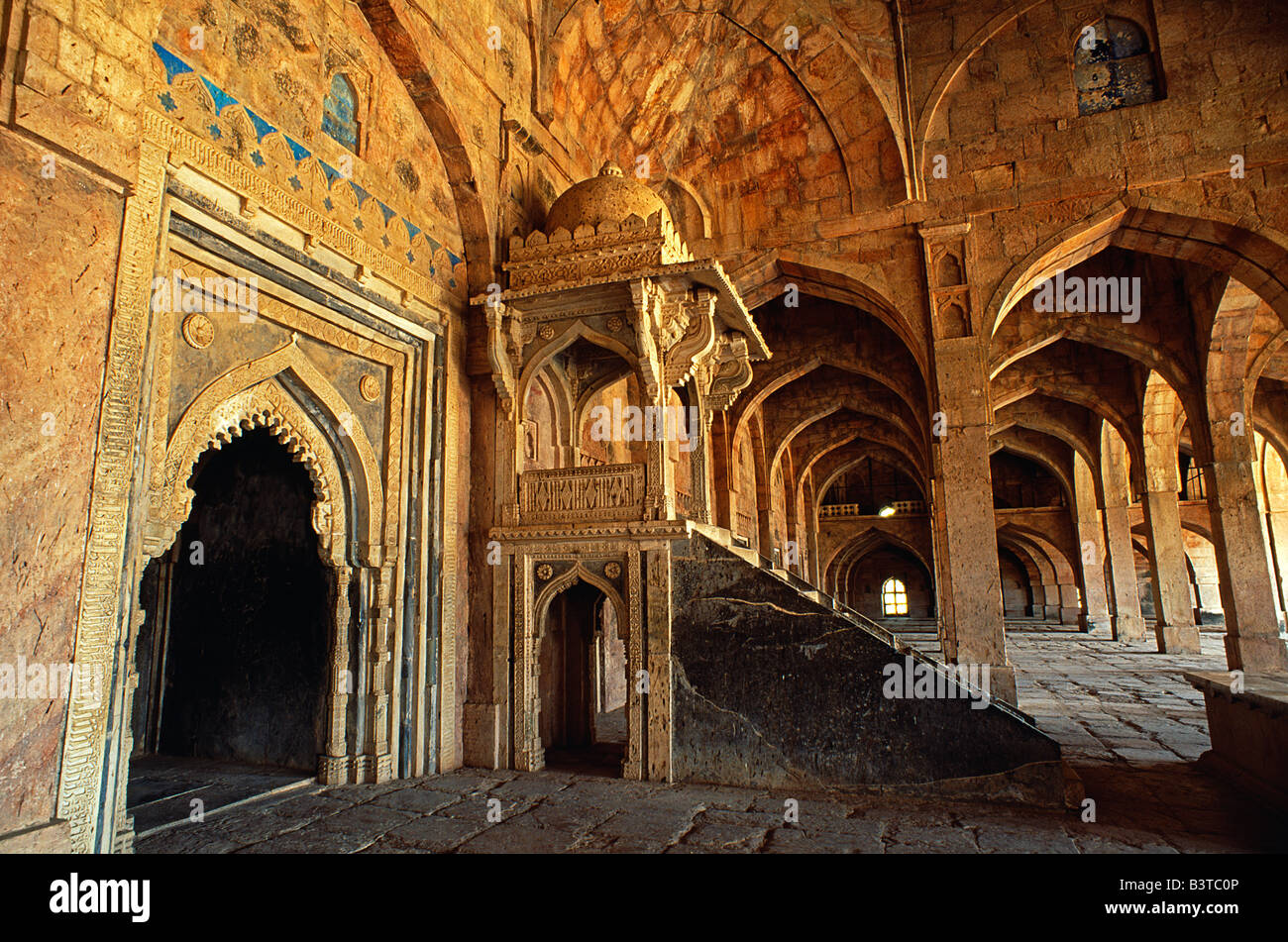 Indien, Madhya Pradesh, Mandu. Jami Masjid, ist eine Zeit Festung Hauptstadt der Sultane von Malwa und später Freude Rückzug der Moguln, Mandus 15. Jahrhunderts Jami Masjid seine feinsten verbliebene Gebäude. Zahlreichen Bögen und Säulen unterstützen seine gewölbte Gebetshalle. Die zentrale Nische gezeigt hier neben einer erhöhten Kanzel ist mit der Schriftrolle des Korans Zitate verziert. Stockfoto