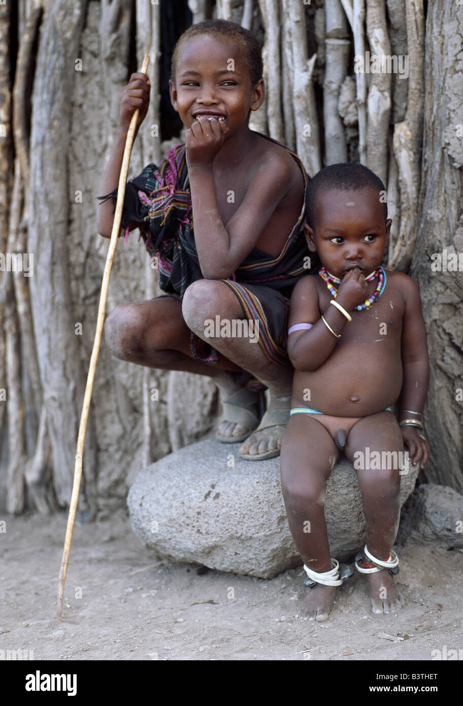 Tansania, Arusha, Lake Eyasi. Zwei jungen Datog. Der jüngste trägt Metallschellen um seine Knöchel um sicherzustellen, dass er nicht weit von zu Hause ohne seine Mutter oder ein anderes Mitglied der Familie, die ihn hören wandern. Die Datog (ihren Maasai Nachbarn als die Mang'ati und der Iraqw als Babaraig bekannt) Leben im Norden von Tansania und sind vor allem Hirten. Stockfoto