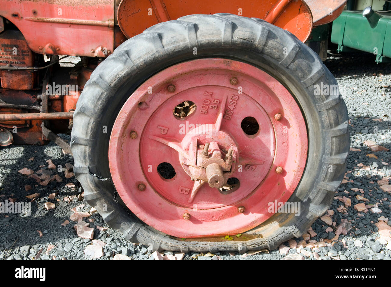Flache Riss Traktor-Reifen auf einem roten Traktor Stockfoto