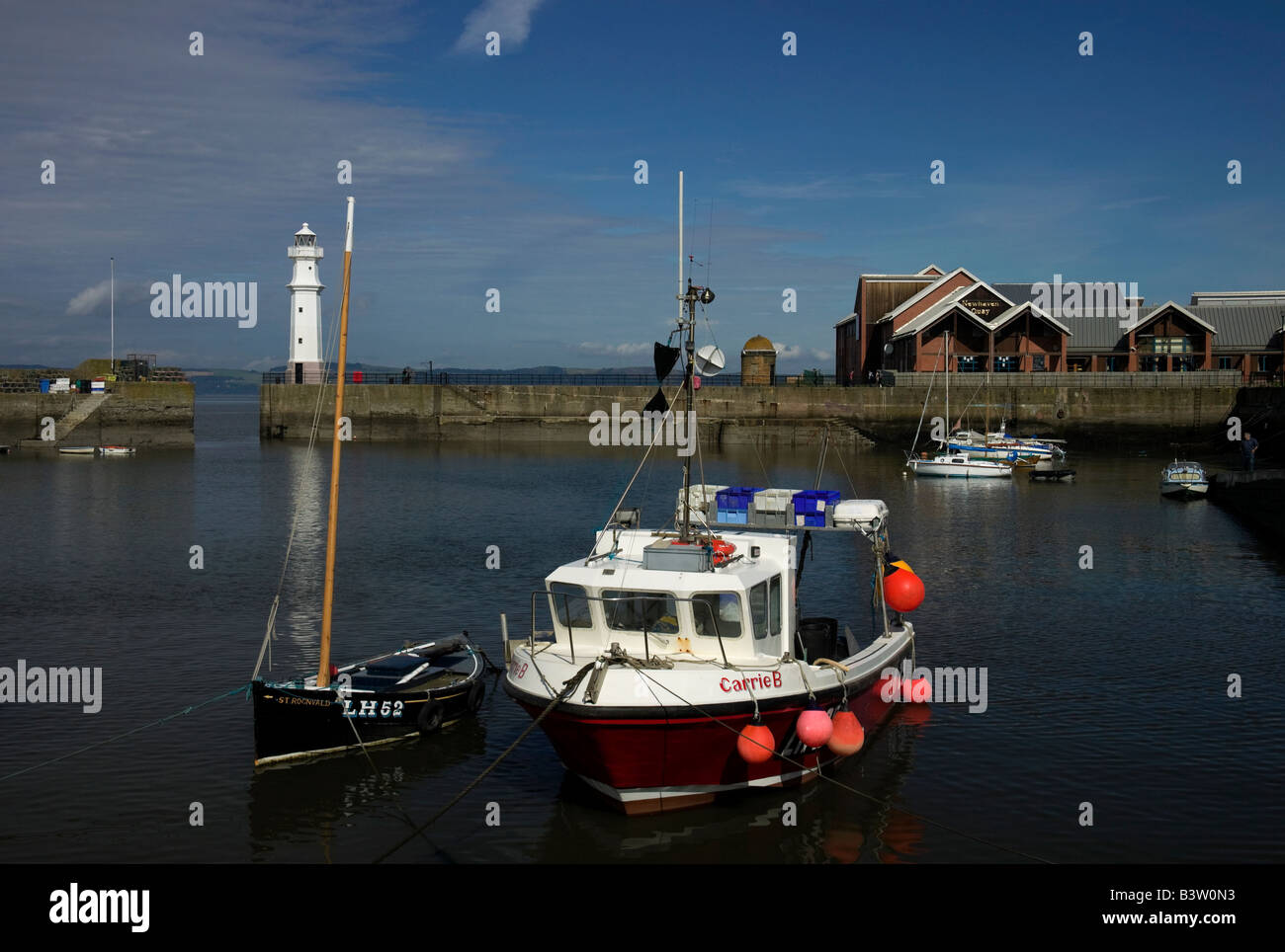 Angelboot/Fischerboot vor Anker im Hafen von Newhaven mit Leuchtturm im Hintergrund, Edinburgh, Scotland, UK, Europa Stockfoto