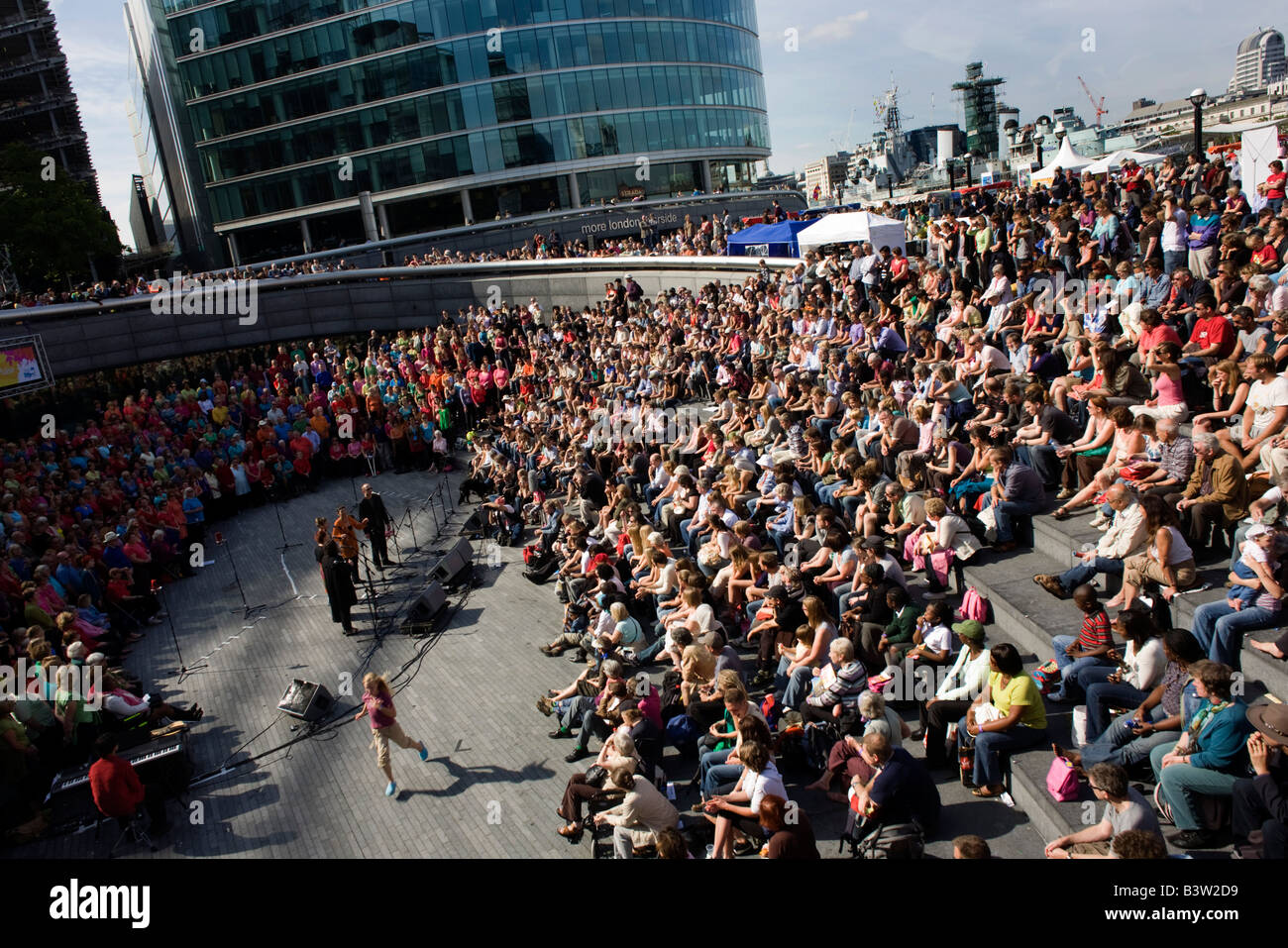 Publikum hört Lieder für Wateraid durch multinationale 1000-Chor bei der Scoop während der Londoner Thames Festival Stockfoto