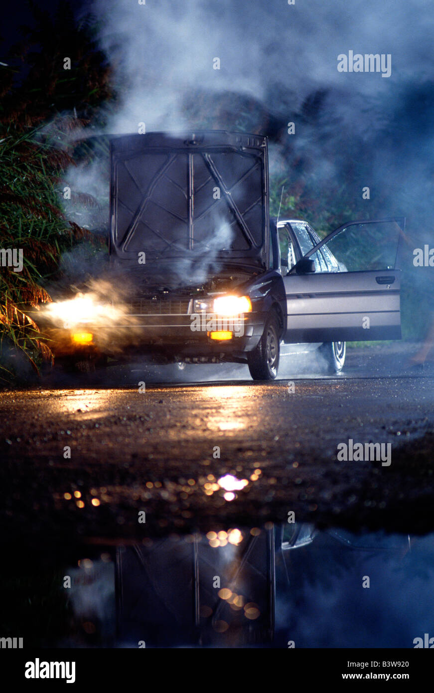 Auto in der Nacht mit Dampf steigt aus dem überhitzten Motor aufgeschlüsselt Stockfoto