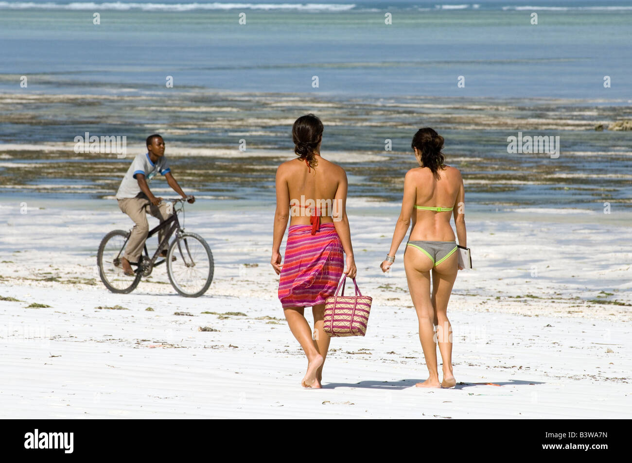 Hotelgäste zu Fuß am Strand entlang, Bwe Juu, Sansibar, Tansania Stockfoto