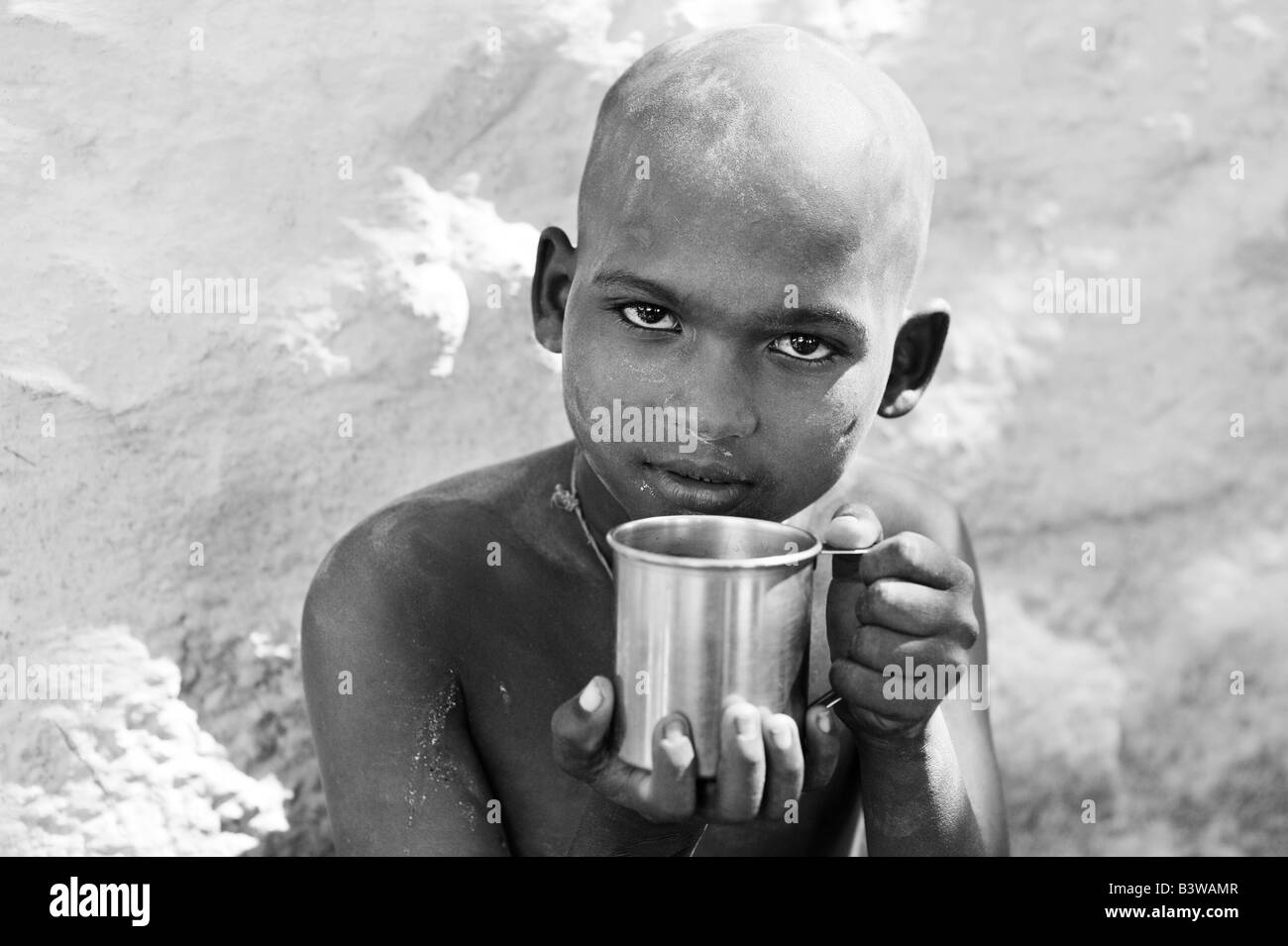 Indischer Junge mit Metall-Becher, Wasser zu trinken Stockfoto
