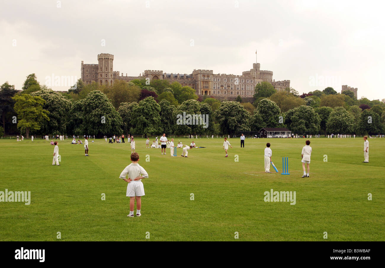 Kinder spielen eine Partie Cricket mit Windor Burg im Hintergrund. Windsor in England. Stockfoto