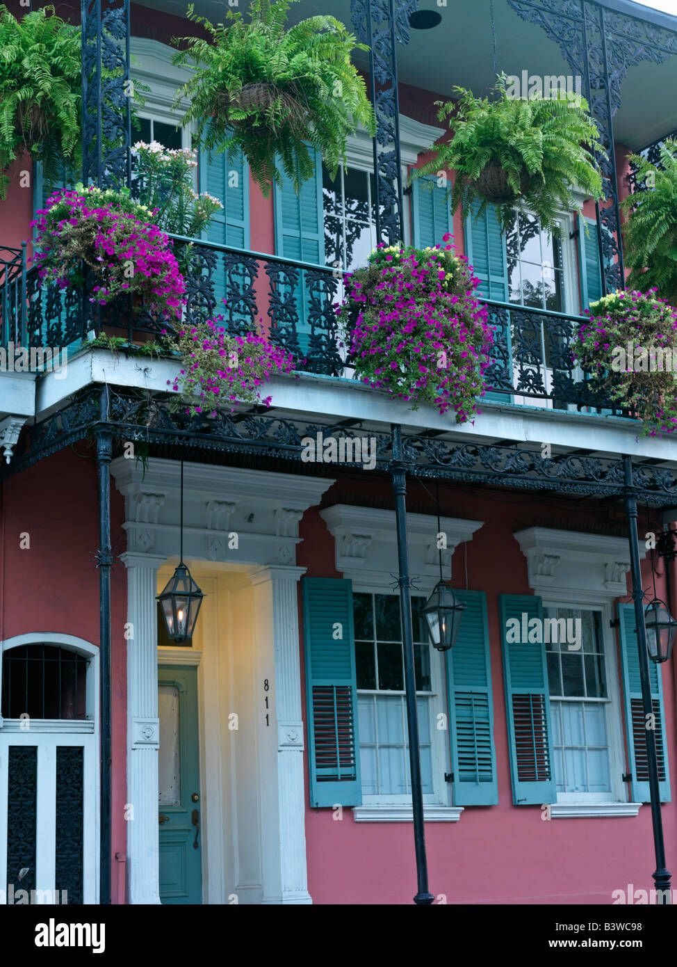 USA, Louisiana, New Orleans, bunte French Quarter Wohnstraße mit schmiedeeisernen Balkonen und hängende Blumenkörbe Stockfoto