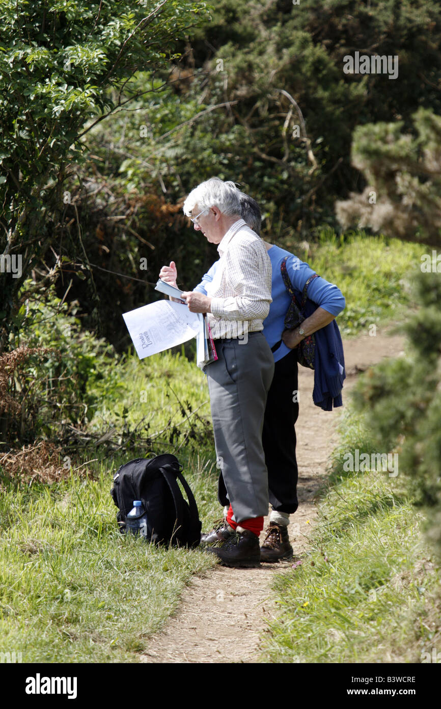 Ältere Paare Beratung Karte auf South West Coast Path Cornwall Stockfoto