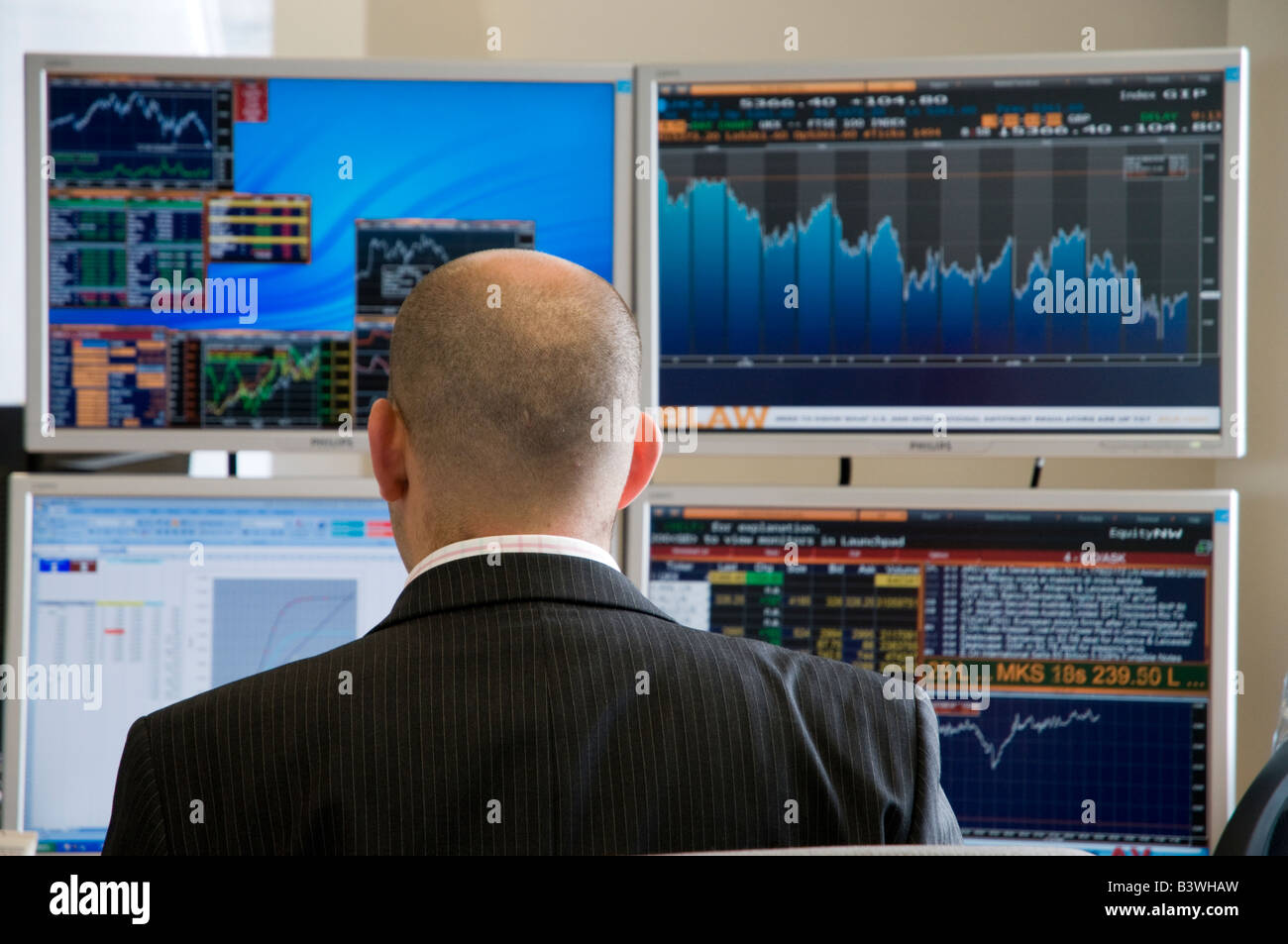 Stadt Hedge Fund Manager vor der finanziellen Pläne auf Computerbildschirmen, London, UK Stockfoto